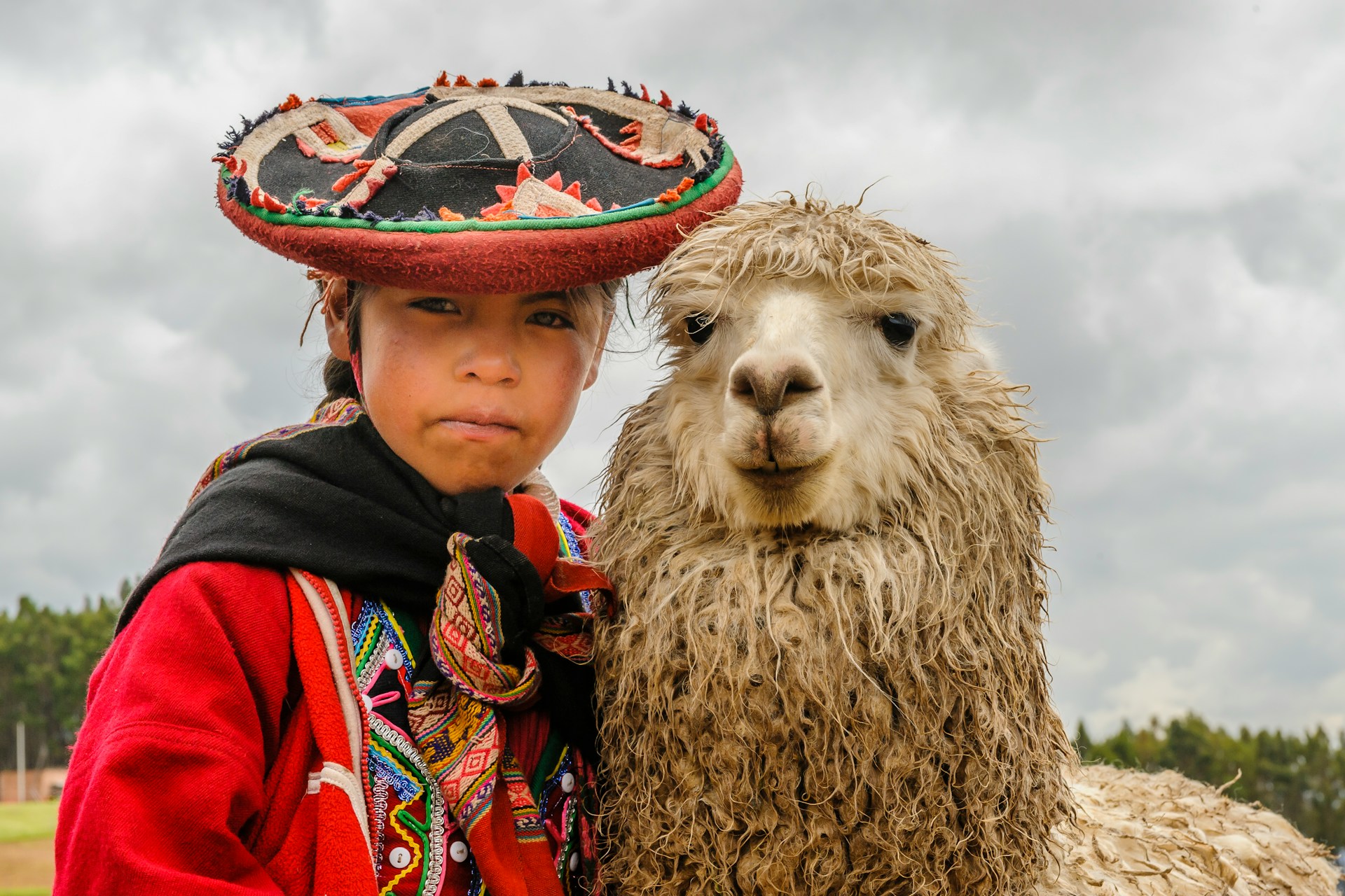 Woman with hat and llama in Peru — part of our Madre de Dios giving back initiative